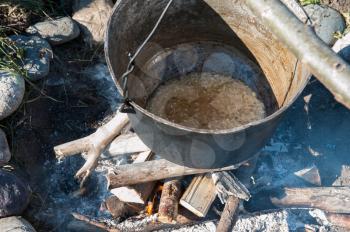 Camping fire and kettle with food