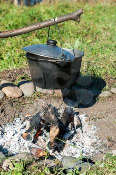 Camping fire and kettle with food