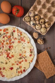 baked omelette with different eggs and vegetables with rye small load of bread