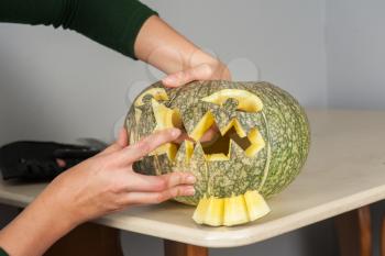 woman hands making pumpkin for halloween holidays.