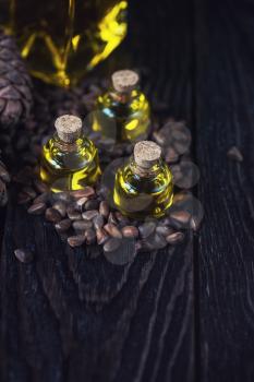Oil of cedar nuts on a dark wooden background