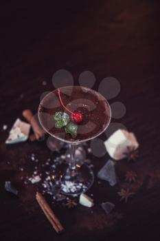 Ice cream chocolate dessert decorated with cherry on dark brown background