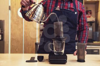 Barista brewing coffee in aeropress in the cafe