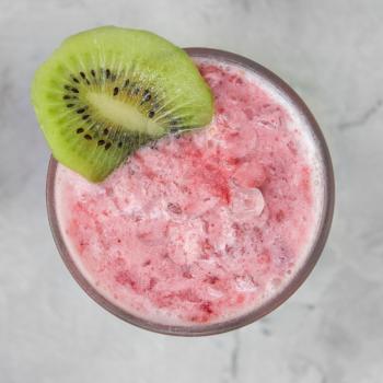 Strawberry smoothie with kiwi on a white concrete background. Square cropping