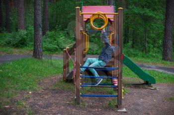Boy at the playground in the forest