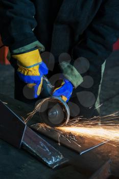 Industry, job concept - worker cutting metal with grinder