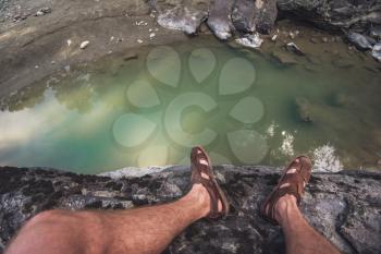 Travel, freedom and tourism concept - male legs on the top of mountain, pov view