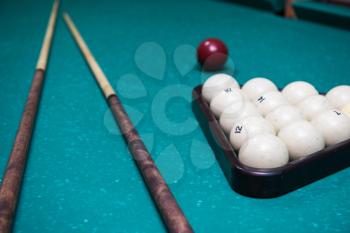 Russian billiard table with balls and cue sticks on a green background