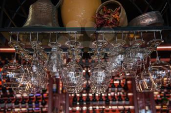 Clean washed glasses hanging over a bar rack