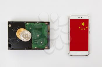 Bitcoin coin on the HDD with smartphone with China flag on white background
