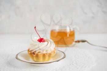 Tasty mini cake with tea on a white background