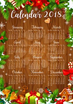 Calendar template of 2018 New Year with Christmas wreath on wooden background. Winter holidays year calendar, edged by Xmas tree, holly berry and Santa bell, gift and snowflake, cookie, candy and sock
