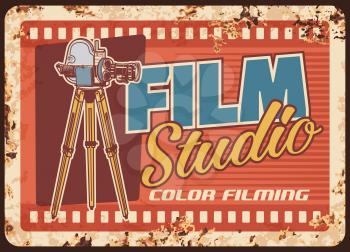 Film studio rusty metal plate, cinema or movie entertainment vector rust tin sign. Vintage video camera with film reels retro poster. Color filming, cinematography industry card with old camcorder
