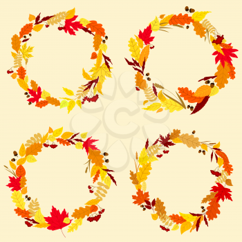 Colorful garlands or wreaths of autumn and fall leaves in shades of orange, red and yellow with central copyspace