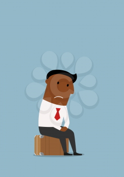 Thoughtful unemployed african american businessman sitting on the suitcase after job loss and worrying about future. Unemployment, jobless, redundancy or job loss business concept