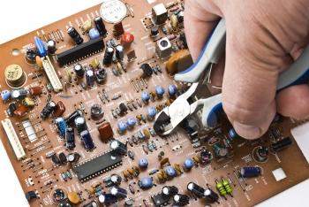 Royalty Free Photo of a Person Repairing a Circuit Board
