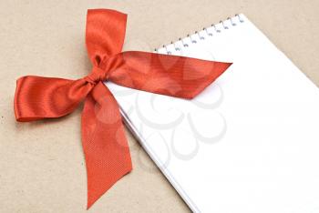 Royalty Free Photo of a Spiral Notepad With a Red Bow