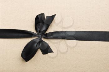 Royalty Free Photo of a Black Bow on Cardboard
