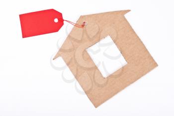 Royalty Free Photo of a Cardboard House With a Red Tag