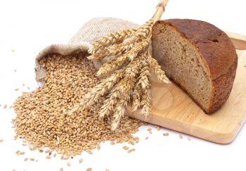 Bread cut on a board, a bag with wheat and ear of the wheat