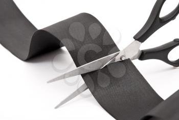 Scissors cutting black ribbon