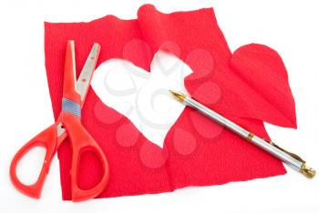 Royalty Free Photo of a Red Cloth With a Heart Cut Out of the Center, a Pair of Scissors, and a Pen