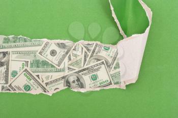 Dollars through torn green paper