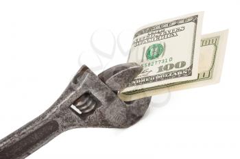 Wrench and bills of U.S. dollar currency