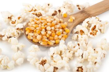Corn seeds and popcorn with wooden spoon