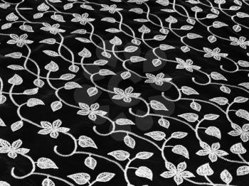 Beautiful lacy cloth with flowers pattern over black background