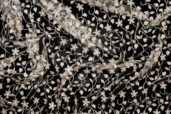 Beautiful lacy tissue with flowers over black background