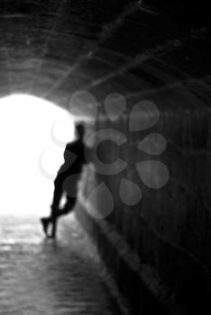 Blurred human silhouette against the light of tunnel exit background (shallow DOF)