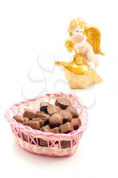 Sweet love - candies in wicker basket and angel on white