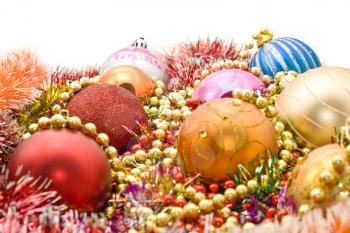 Colorful Christmas decoration - baubles, tinsel, beads over white