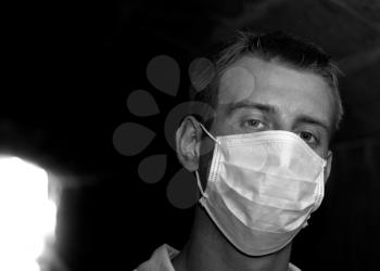 Man with gauze bandage in dark tunnel (black and white image)
