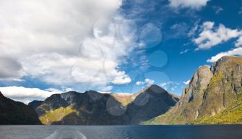 Mountains and norwegian fiord. Clouds and blue sky