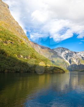 Norwegian fjords in autumn: Mountains, river and blue sky