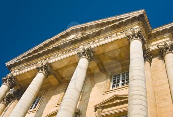 Palace facade with columns in Versailles over blue sky. France