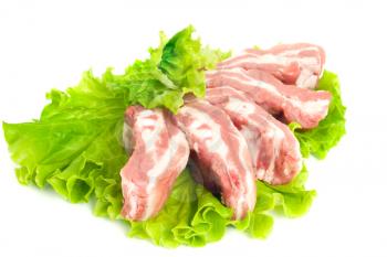 Pork meat pieces on green salad. Isolated over white