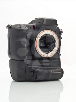 Professional Dslr camera body with vertical grip and its mirror over white background
