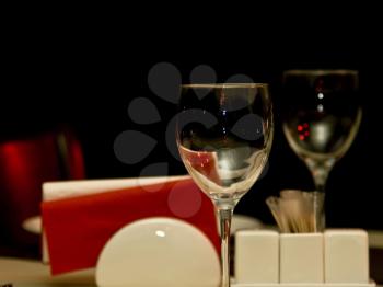 Restaurant - wineglasses and table appointments in the dark (focus on wineglass, shallow DOF)