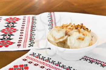 Ukrainian Traditional cuisine - dumplings with fried onion on traditional embroidered towel