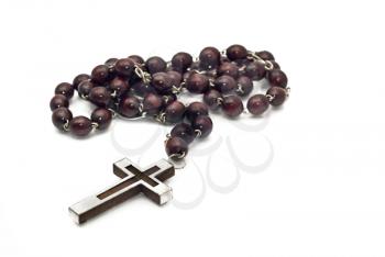 Wooden beads with metallic cross isolated over white (shallow DOF focus on cross)