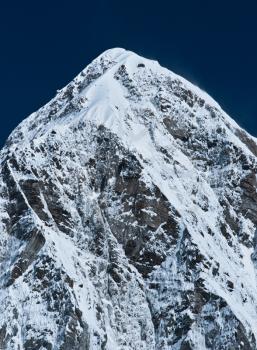 Himalayas: Pumori mountain peak and blue sky. Nepal