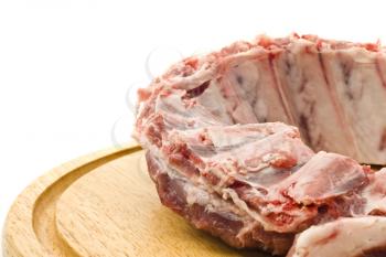 Uncooked Pork ribs with raw meat on round hardboard over white