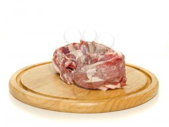 Raw meat on round hardboard over the white background