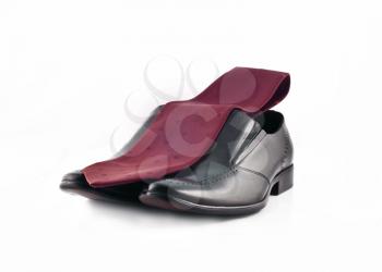 Tie and a Pair of man's classic leather shoes isolated over white background