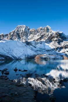 Mountains and reflection in Sacred Gokyo Lake in Himalayas. Travel to Nepal