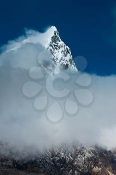 Cholatse mountain peak hidden in clouds. Himalayas