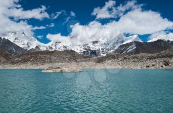 Clouds and Sacred Lake with mountain peaks near Gokyo in Himalayas. Captured in Nepal